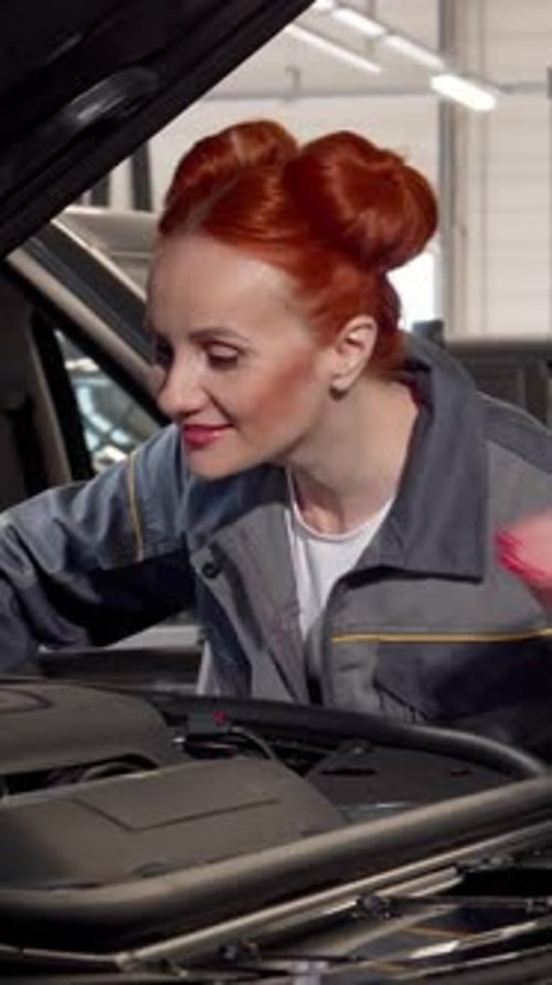 Une mécanicienne confiante inspecte un moteur de VUS moderne dans un garage lumineux