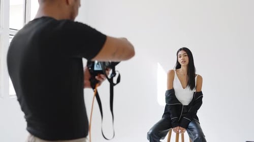 Professional Photographer Taking Pictures of Model in Studio