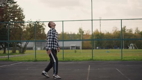 Man Tossing Volleyball in Outdoor Court Preparing to Strike