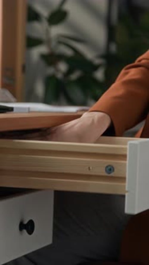 Female Office Employee Securing Documents with Paper Clamp at Desk