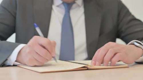 Hands Close Up of Businessman Writing on Notebook