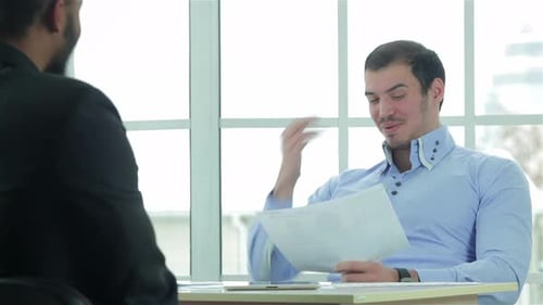 Two Men Discussing Documents in Modern Office