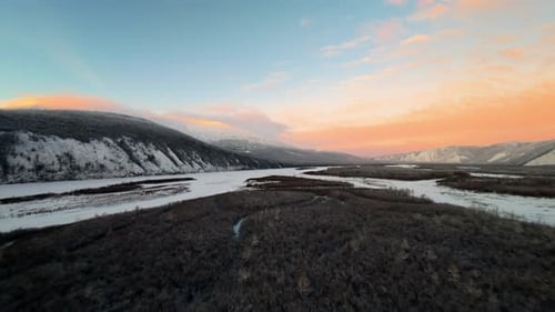 Breathtaking winter landscape at sunset over a winding river in a mountainous region