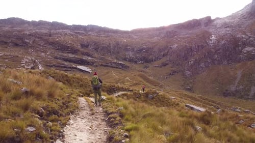 Tracking Shot Of Group Of Campers Hiking In Green Mountains Landscape, Peru