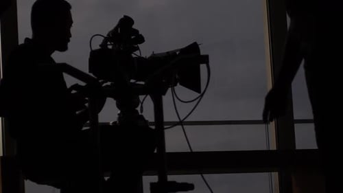 Silhouette of a Camera Crew Working at Night