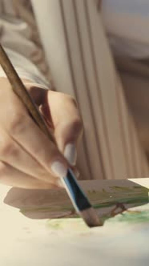 Woman Painting Watercolor with Brush Indoors in Daylight