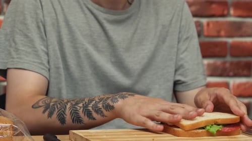 Man Making Sandwich with Salami and Lettuce