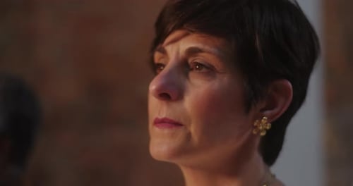 Gros plan d'une femme aux cheveux courts, hochant la tête en signe d'affirmation, prêtant attention au public