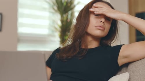 Tired Woman with Laptop in Cozy Home