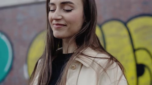 Stylish Woman Smiles in Front of Graffiti Wall
