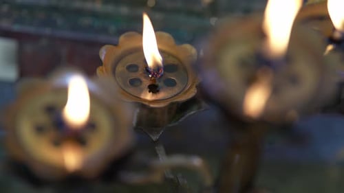 Close up slow motion Chinese temple oil lamp offering
