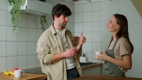 Couple Talking and Drinking in Modern White Kitchen