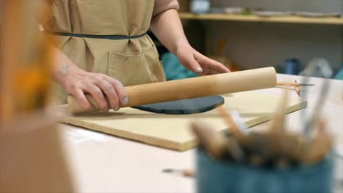 The master of sculpting pottery working in a studio. Rolling out the clay