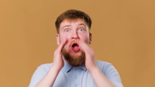 Redheaded Guy Screams with Excitement While Looking at the Camera in a Studio Shot