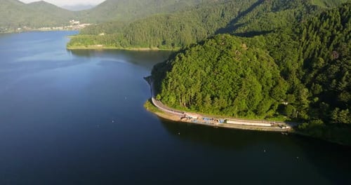 Aerial view tilting over lake Kawaguchi, revealing mountains, summer day in Japan