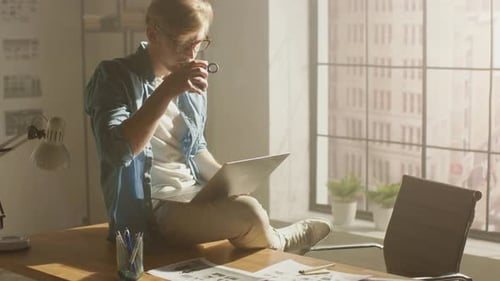 Man works at computer, sits on office desk