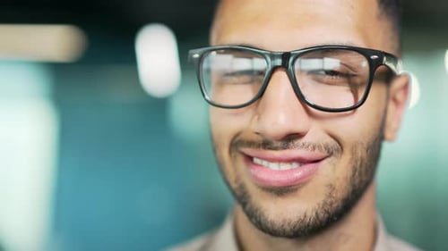 Close up portrait young man in glasses and shirt smiling and looking at camera while standing