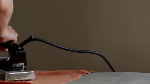 Hand Turning on Metallic Iron, Close Up