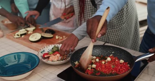 African family cooking together at home patio - Close up of hands and cooking pan