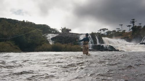 Lone Fisherman Fly Fishing by a Waterfall