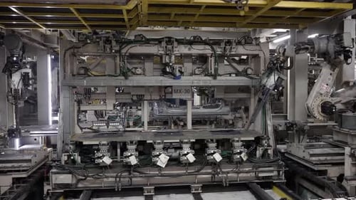Automated car body welding process at a car manufacturing facility.