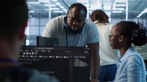 Colleagues coding together in a high-tech office