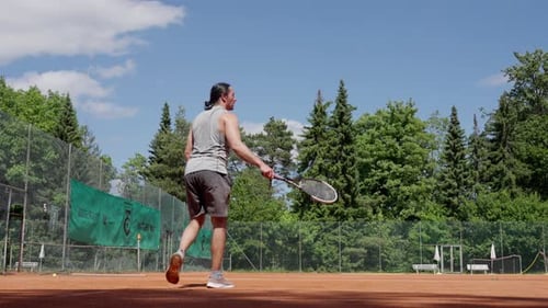 A Skilled Athlete Practicing Tennis on a Sunlit Court Amidst Lush Greenery Showcasing Professional