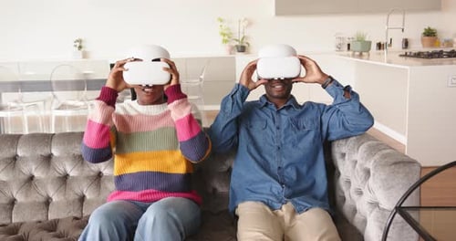 Couple Laughing Wearing VR Headsets at Home