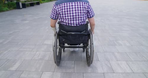 Adult in Wheelchair Moving Through Urban Park
