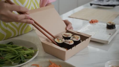 Hands of Housewife Putting Self-made Gimbap in Box for Takeaway