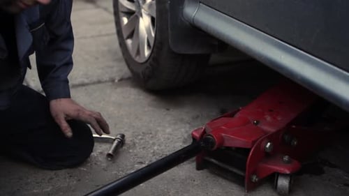 Mechanic Working on Car Tire with Jack