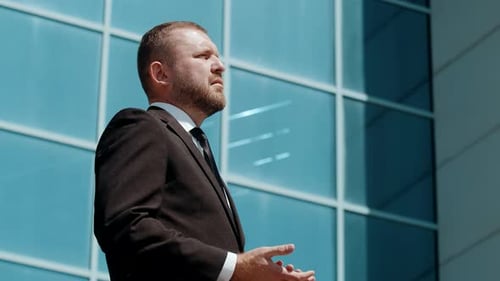 Confident Businessman Standing in Front of Office Building