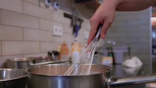 Die Sauce mit einem Schneebesen umrühren (Carbonara-Sauce, Kochen für Spaghetti und Pasta, Kochen von cremigen Nudeln)