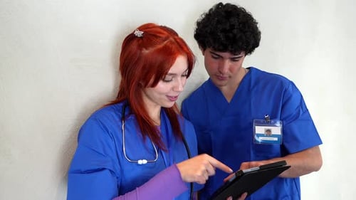 Medical staff discussing patient information on tablet