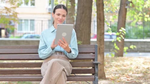 Video Chat on Tablet by Young Woman Outdoor