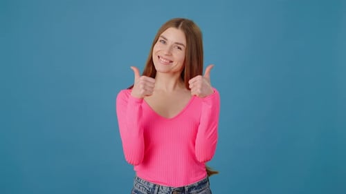 Smiling Woman Giving Thumbs Up on Blue Background