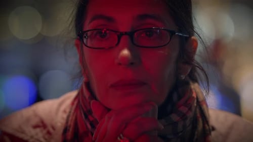 Woman with Dark Hair and Glasses Looking Intently