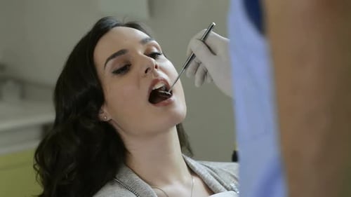 Portrait Of A Patient To The Dentist For A Check Up And A Dental Cleaning. Dentist Checks The Tee...