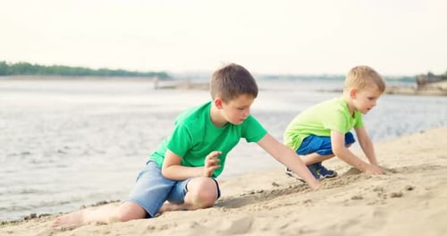 Kids Playing with Sand on Sea Beach in Warm Sunshine in the Summer