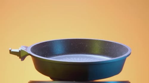 Schwarze Bratpfanne auf orangefarbenem Hintergrund