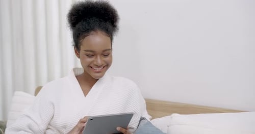 Woman Smiling, Using Tablet in Bed at Home