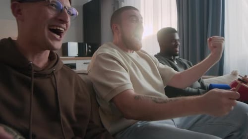 Enthusiastic Friends Celebrating Victory Together on Couch