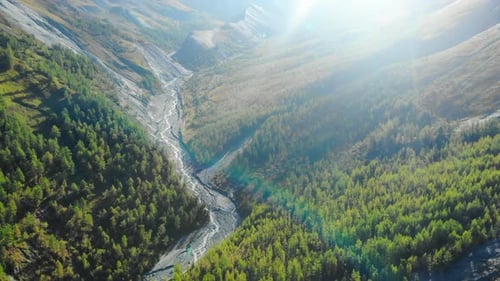 River Flowing Through Green Valley Illuminated By Sunlight Media