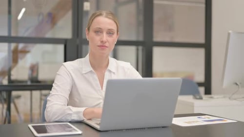 Mature Business Woman Smiling at Camera in Office