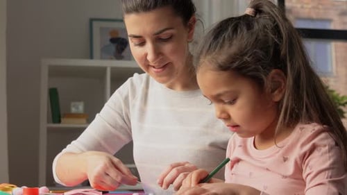 Woman and Girl Crafting Together at Table Indoors