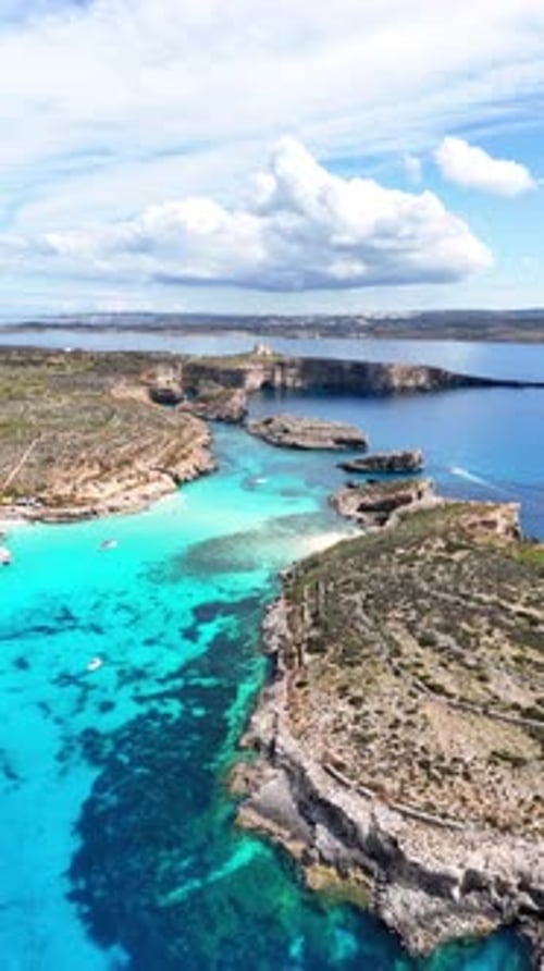 Drone vertical survolant le Blue Lagoon Comino, l'eau turquoise et la côte calcaire de Malte