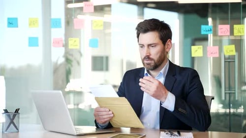 Man Reads Documents in Bright Modern Office