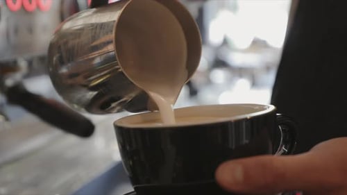 Close Up Barista Pouring Steamed Milk with Pattern Into Cappuccino at Espresso