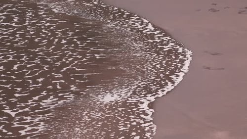 Gentle Waves Lapping onto a Sandy Beach Shoreline