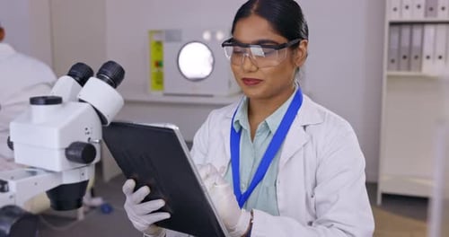 Female Scientist Uses Tablet in Laboratory Setting